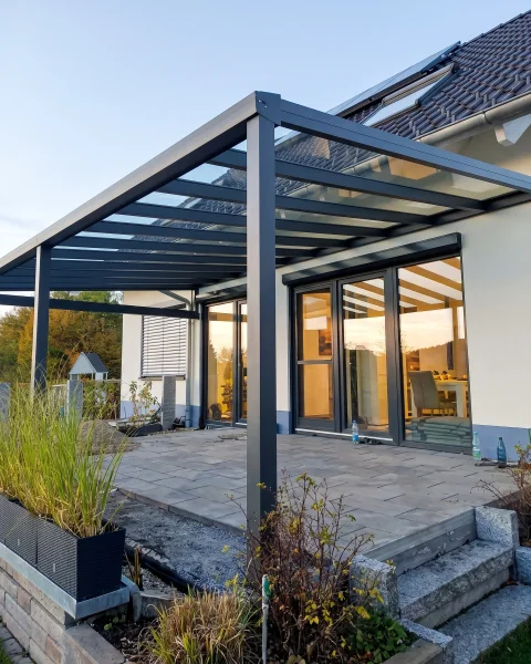 Terrassenüberdachung aus anthrazitfarbenem Aluminium und Glas